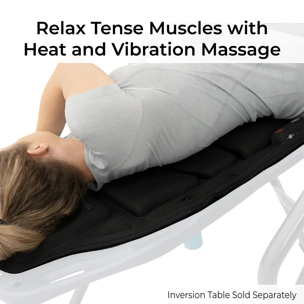 A woman in a grey shirt enjoys the FitSpine Heat and Vibration Comfort Cushion by Teeter, which offers soothing heat and vibration massage to relax tense muscles