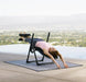 Lady with pink shirt stretched out on her back on the mini inversion table with LA Skyline background