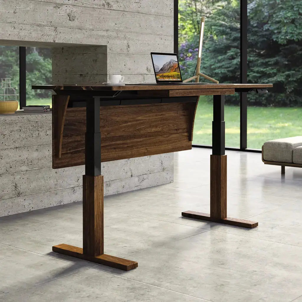 Invigo Sit Stand Desk in Walnut in the standing position in a home setting.