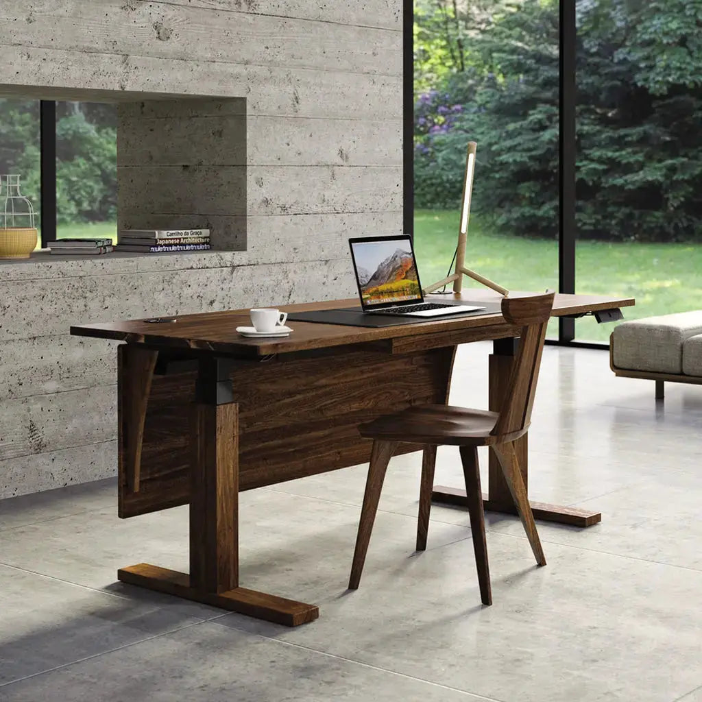 Invigo Sit Stand Desk in Walnut in the sitting position with a wooden desk chair