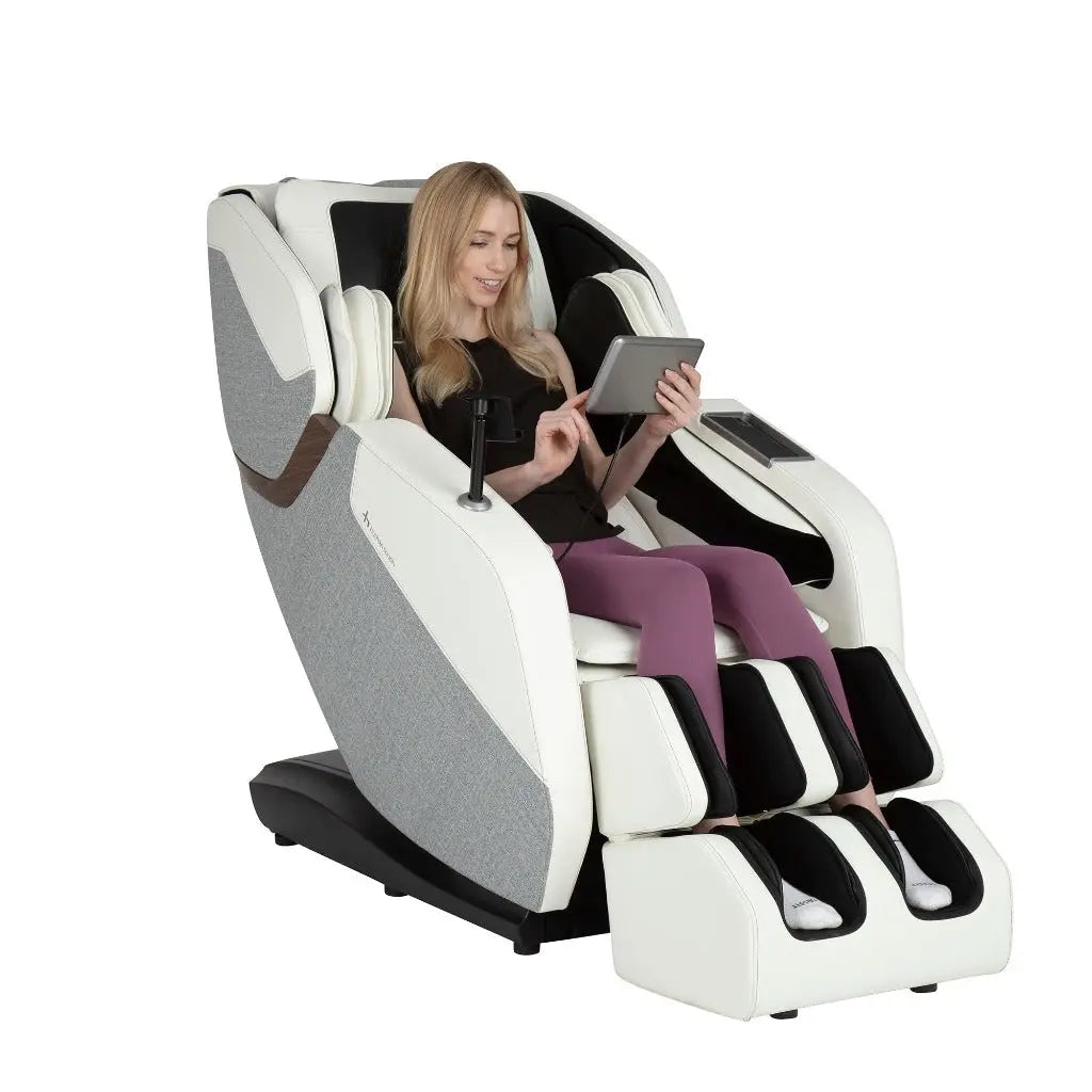 A woman in the WholeBody® ROVE Massage Chair by Human Touch® using the remote on a white background