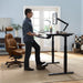 Man using the standing features of the AdaptDesk Standing Desk in his home office