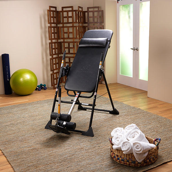Women's entire body reclined back using the Mastercare Back-A-Traction Inversion Table
