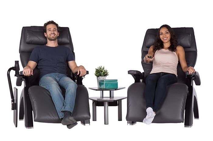 Front view of a woman and man sitting on a Perfect Chairs next to a the Perfect Chair Media Table by Human Touch
